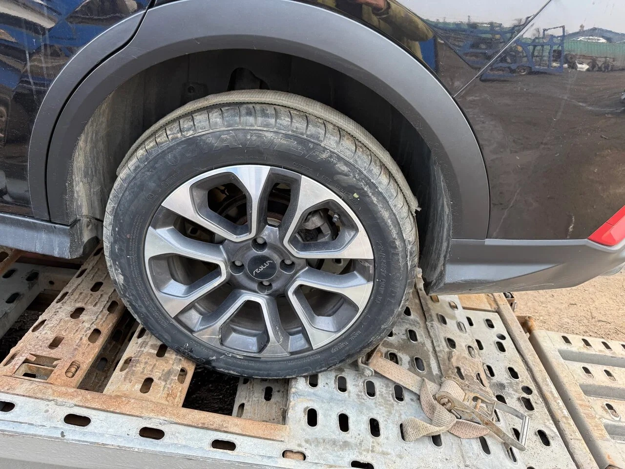 Колесо автомобиля на площадке автовоза перед фиксацией